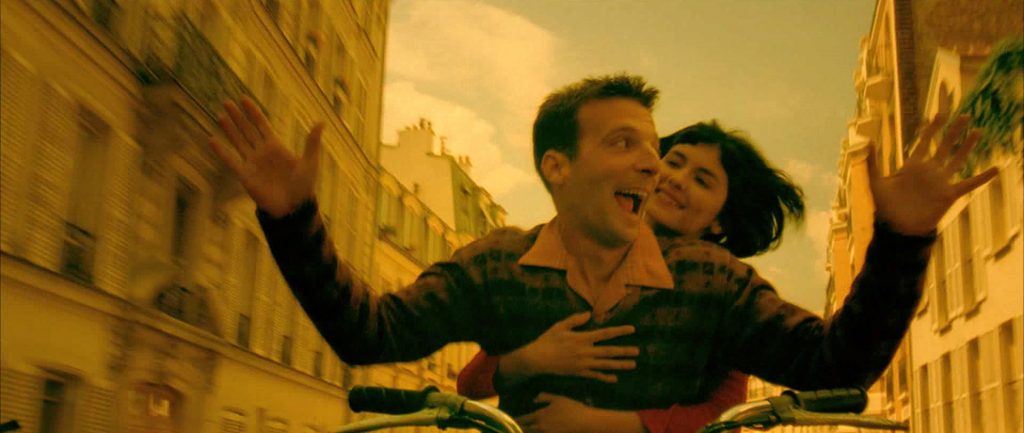 Amelie y Nino en su icónica escena final conduciendo por las calles de París.