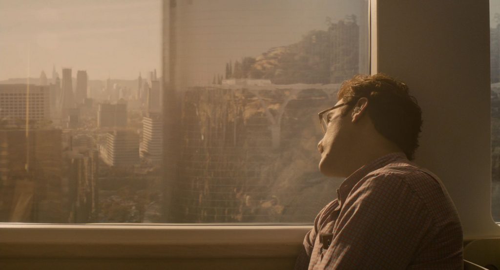 Theodore regresando a casa en el metro mientras se relaja mirando por la ventana en la película Her.